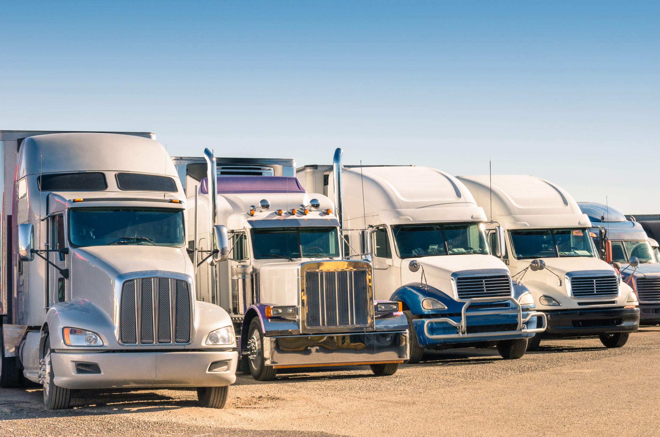 Industrial semi trucks lined up on a lot