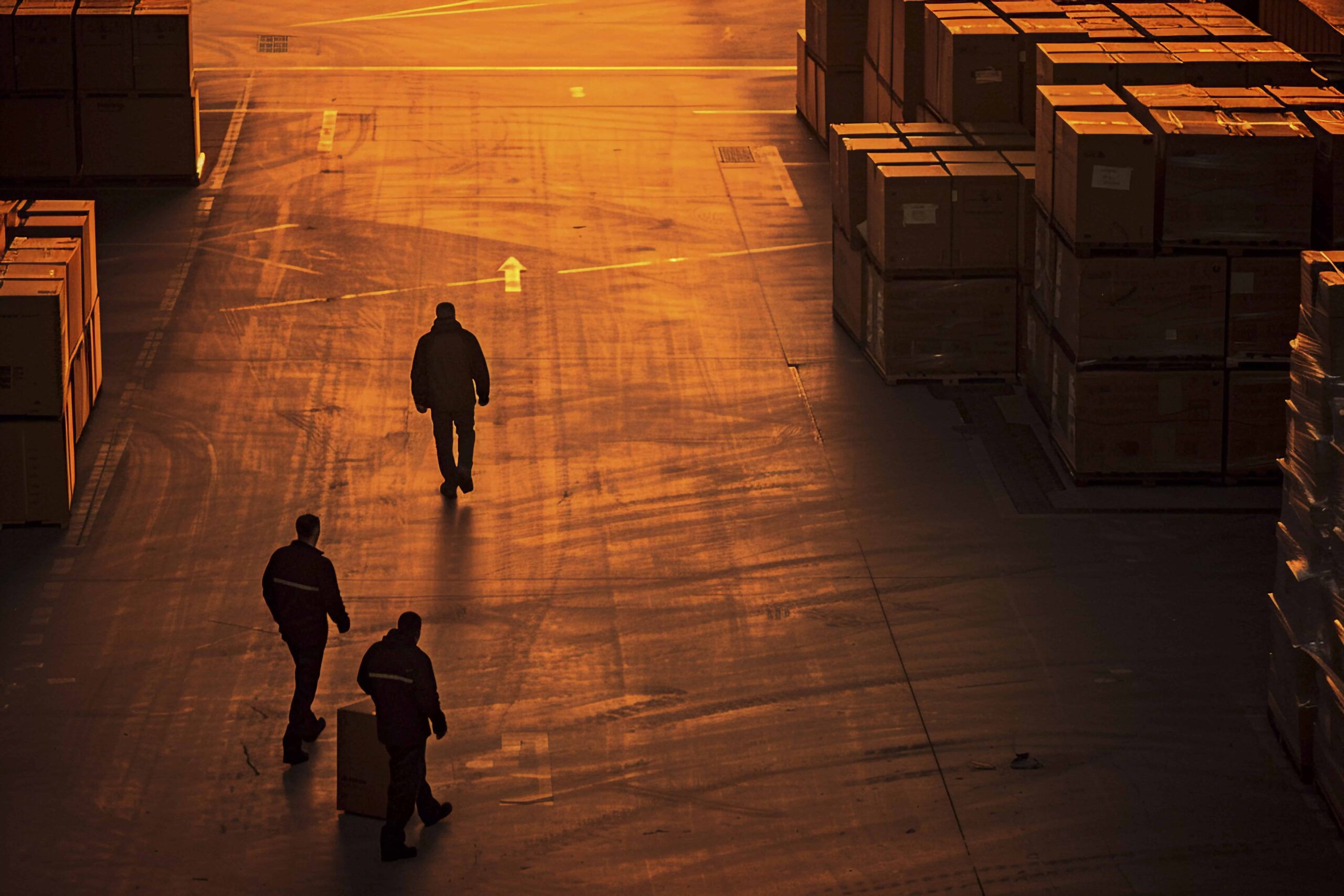 Three Men Walking Through Logistics Warehouse Three Men Walking Through Logistics Warehouse